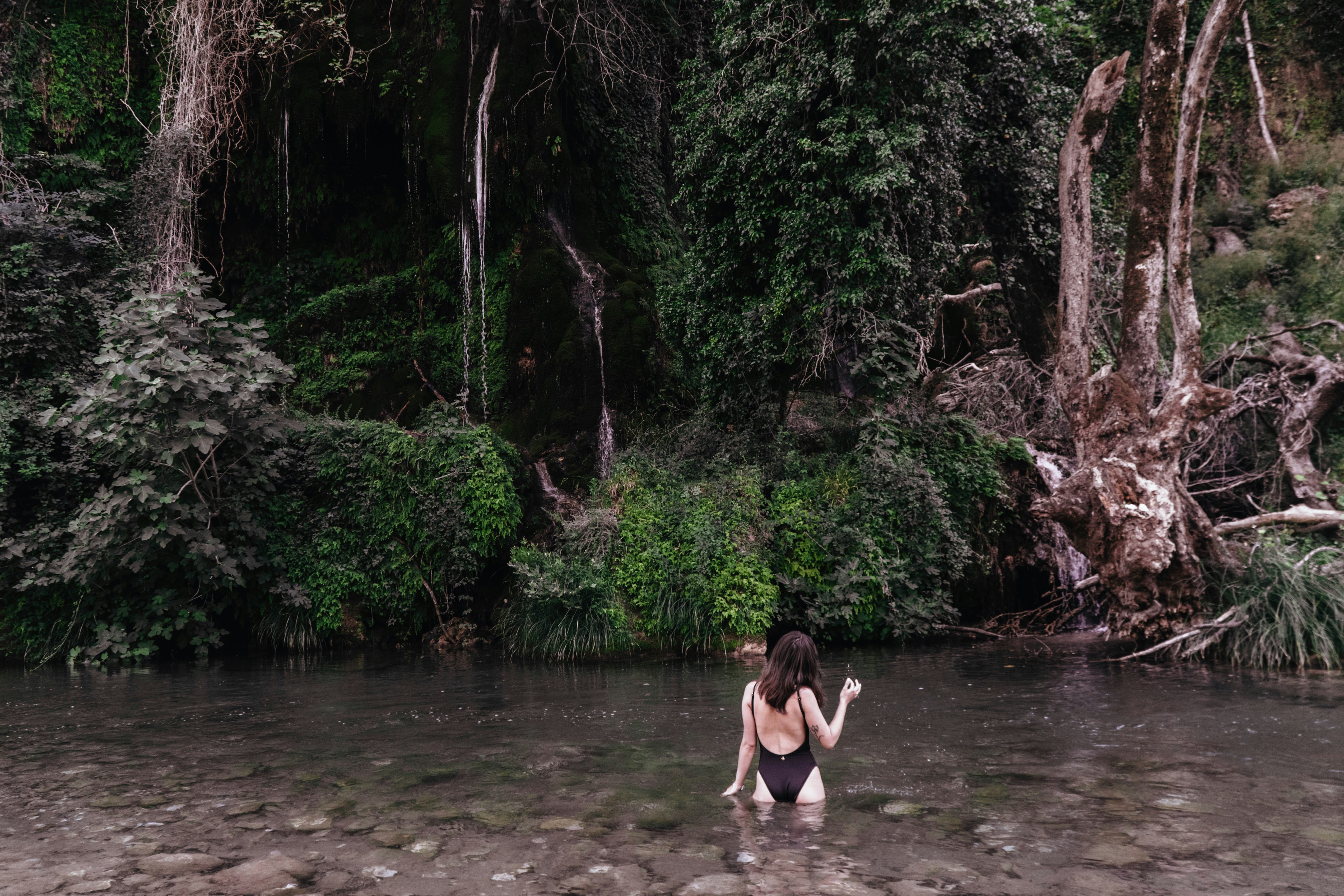 2 women in black bikini on river during daytime